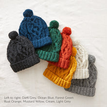 Collection of AJAY wool bobble hats in dark grey, ocean blue, forest green, rust orange, mustard yellow, cream and light grey colourways