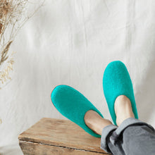 Person wearing seaglass aqua blue wool MITA mule slippers at home with felted wool uppers.