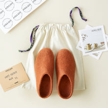 Rust brown wool MITA slippers shown with AURA QUE cotton gift bag, note card and packaging.
