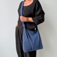 Handmade blue cotton shoulder bag with soft drape and knotted shoulder straps on neutral background
