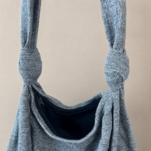 Close-up of handmade grey cotton shoulder bag showing knotted straps and secure zipper closure