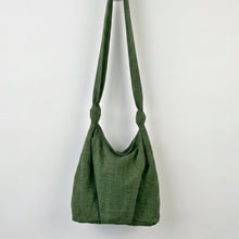 Woman wearing handmade ivy green cotton crossbody bag with adjustable knotted strap and relaxed minimalist design