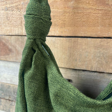 Close-up detail of ivy green woven cotton bag showing handcrafted texture and knotted strap construction