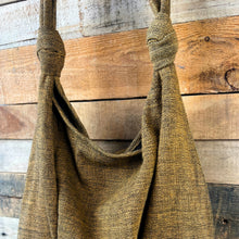 Close-up of yellow textured cotton slouch shoulder bag with knotted strap detail and soft draped design