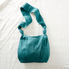 Teal green handwoven cotton crossbody bag with soft slouchy shape and long strap.