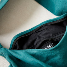 Teal green cotton crossbody bag with zip closure and black cotton lining detail.
