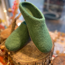 Handmade green felted wool slippers with a slip-on mule shape, styled on a wooden display.