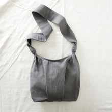 Grey handwoven cotton crossbody bag with roomy slouchy shape and wide long strap.