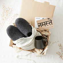 Handmade grey wool slippers packed in an AURA QUE gift box with a mug and cotton bag.
