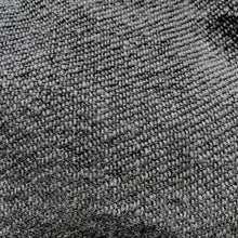 Close-up detail of black woven cotton fabric showing textured artisan weave and natural fibre pattern
