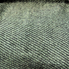 Close-up detail of green woven cotton fabric showing artisan weave texture and natural fibre pattern