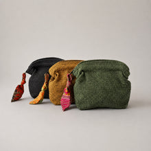 Handmade cotton toiletry bags in black mustard and green displayed on soft grey background