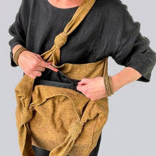Woman carrying a handmade yellow cotton tote bag featuring a secure inner zipper pocket and soft shoulder strap