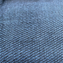 Close-up texture of blue woven cotton fabric showing artisan weave detail and natural fibres