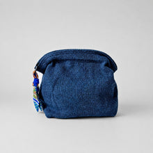 Handmade blue cotton cosmetic pouch with zip closure and patterned fabric zip pull on soft grey background