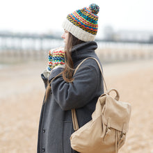 Woman wearing a beige cotton canvas backpack outdoors with winter clothing in a casual travel lifestyle setting.