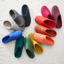 AURA QUE MITA felted wool slippers shown in multiple colourways, including green, blue, grey, pink, red and natural shades.