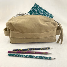 Beige canvas organiser pouch used as pencil case with handcrafted pencils and charging cable.