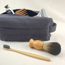 Handmade grey canvas toiletry pouch with eco-friendly grooming accessories and minimalist travel styling.