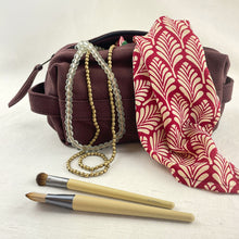 Rust canvas makeup pouch styled with jewellery, scarf and eco-friendly makeup brushes.