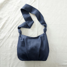 Navy blue handwoven cotton crossbody bag with soft slouchy shape and long comfortable strap.
