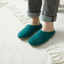 Person wearing teal wool MITA mule slippers at home with felted wool uppers and suede soles.
