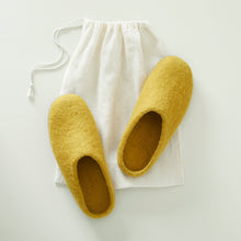 Handmade yellow wool MITA mule slippers shown with an AURA QUE cotton storage bag.