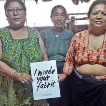 Nepal artisans holding handmade fabric sign for banana yarn textile production